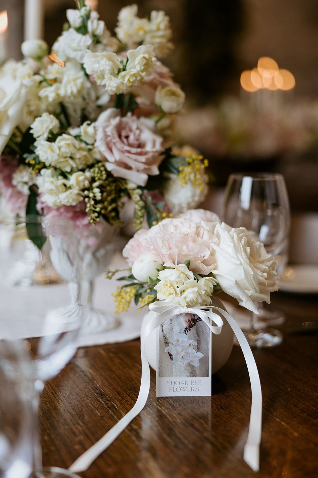 Small posy in a ceramic vase with a Sugar Bee Flowers tag on the guest table